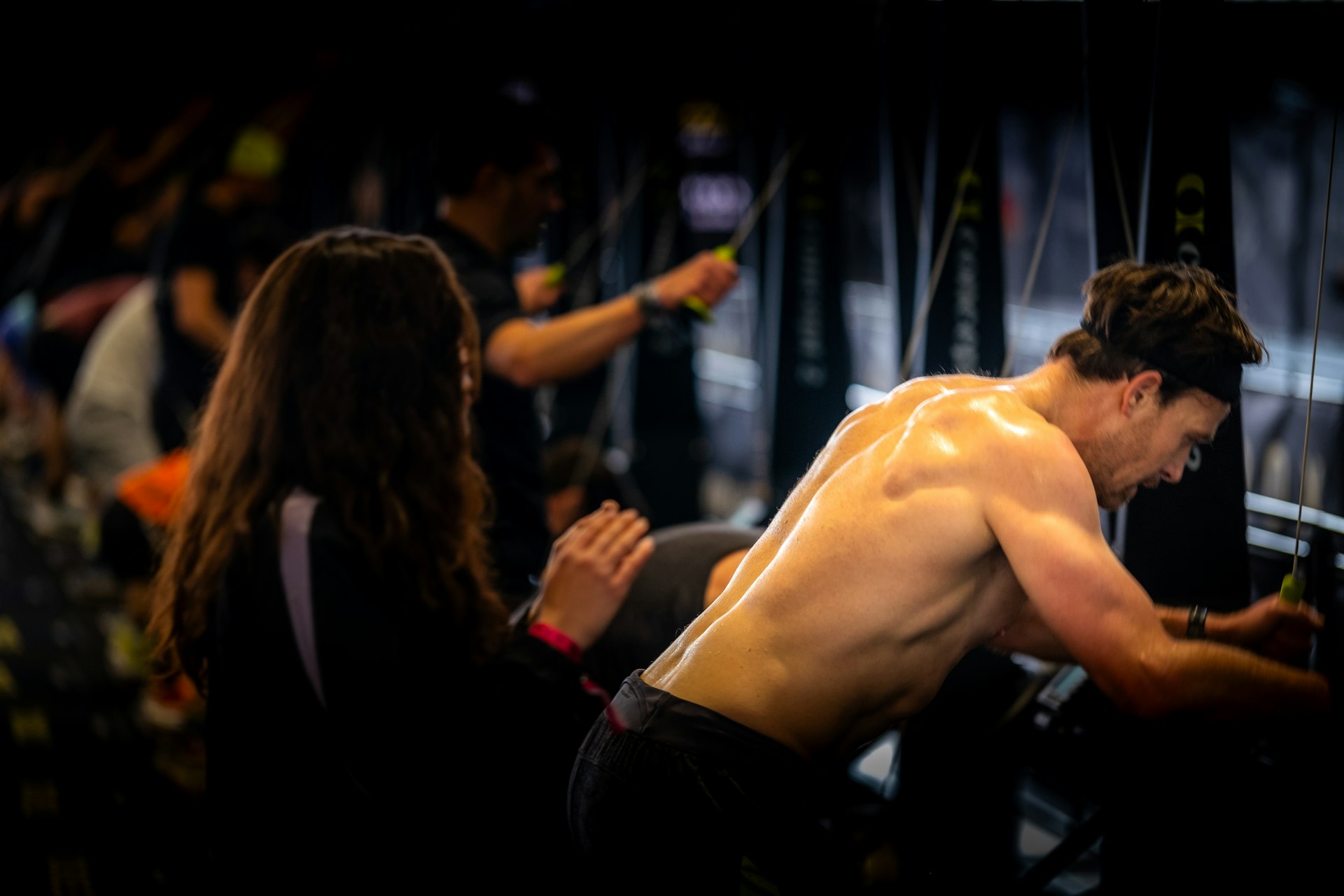 A man with no shirt standing next to a woman